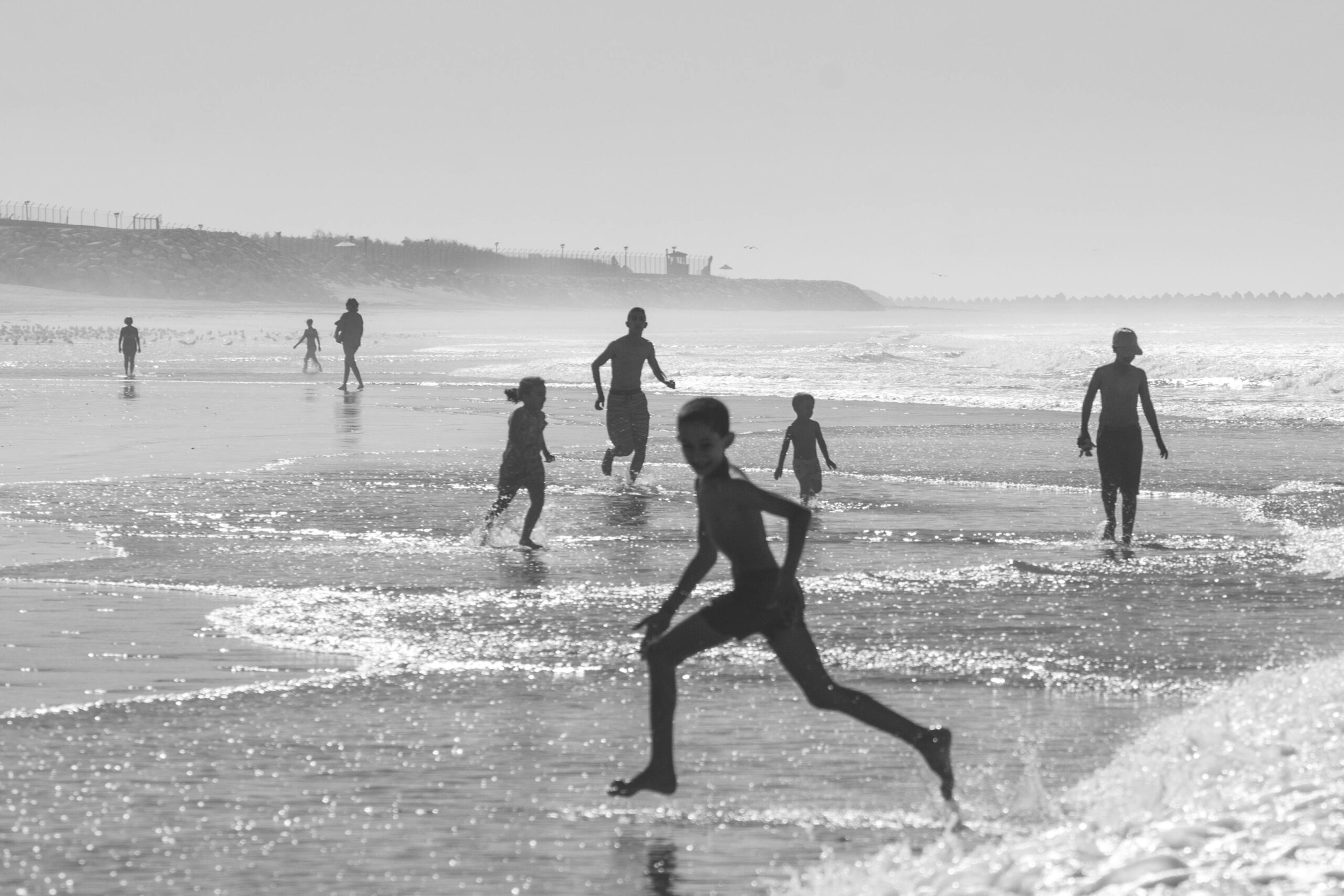 Black and white photo of children enjoying a carefree day at Agadir Beach, Morocco.